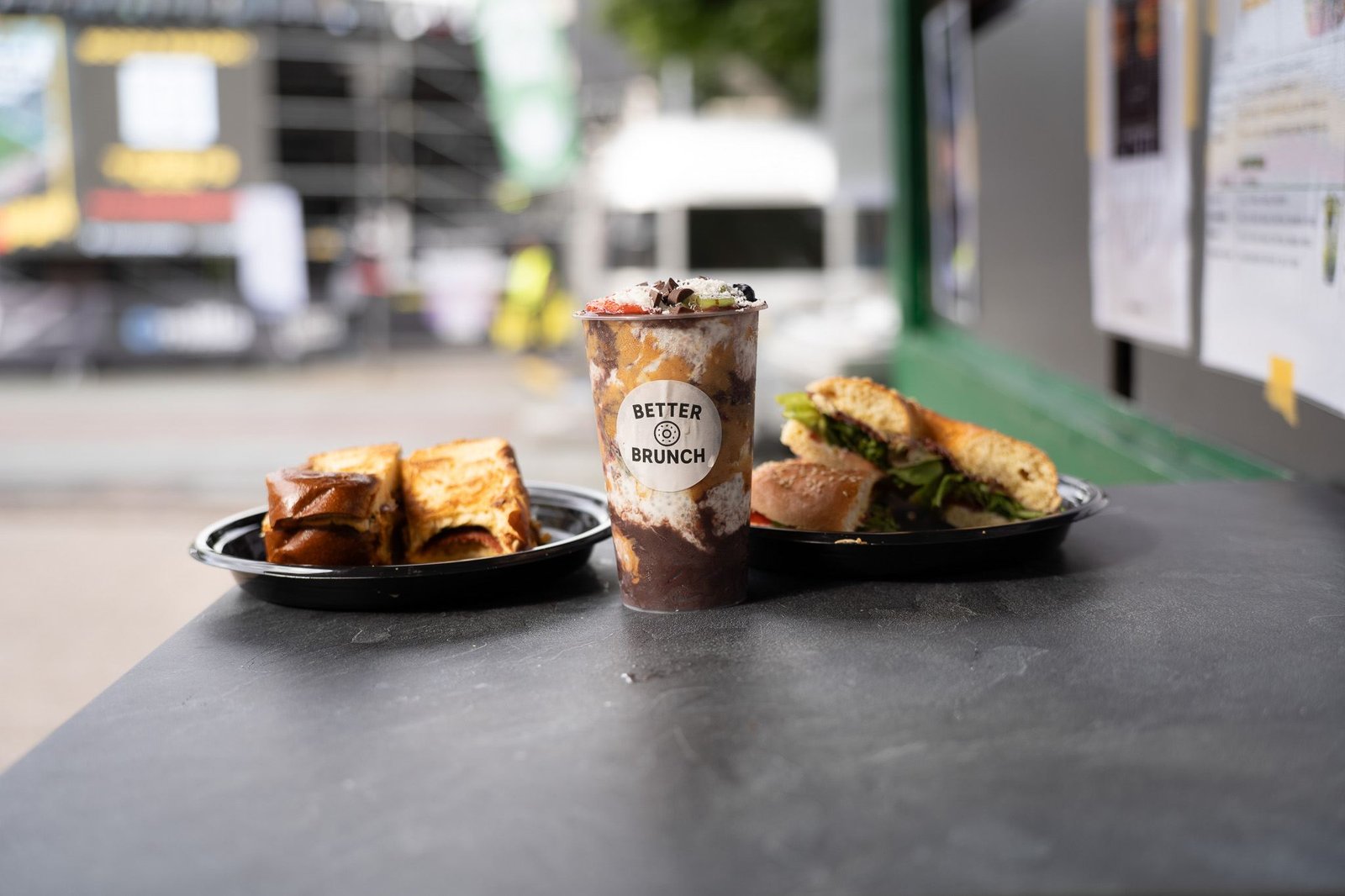 Egg Drop, Açaí Bowl und ein belegter Bagel nebeneinander auf dem Tresen des Foodtrucks